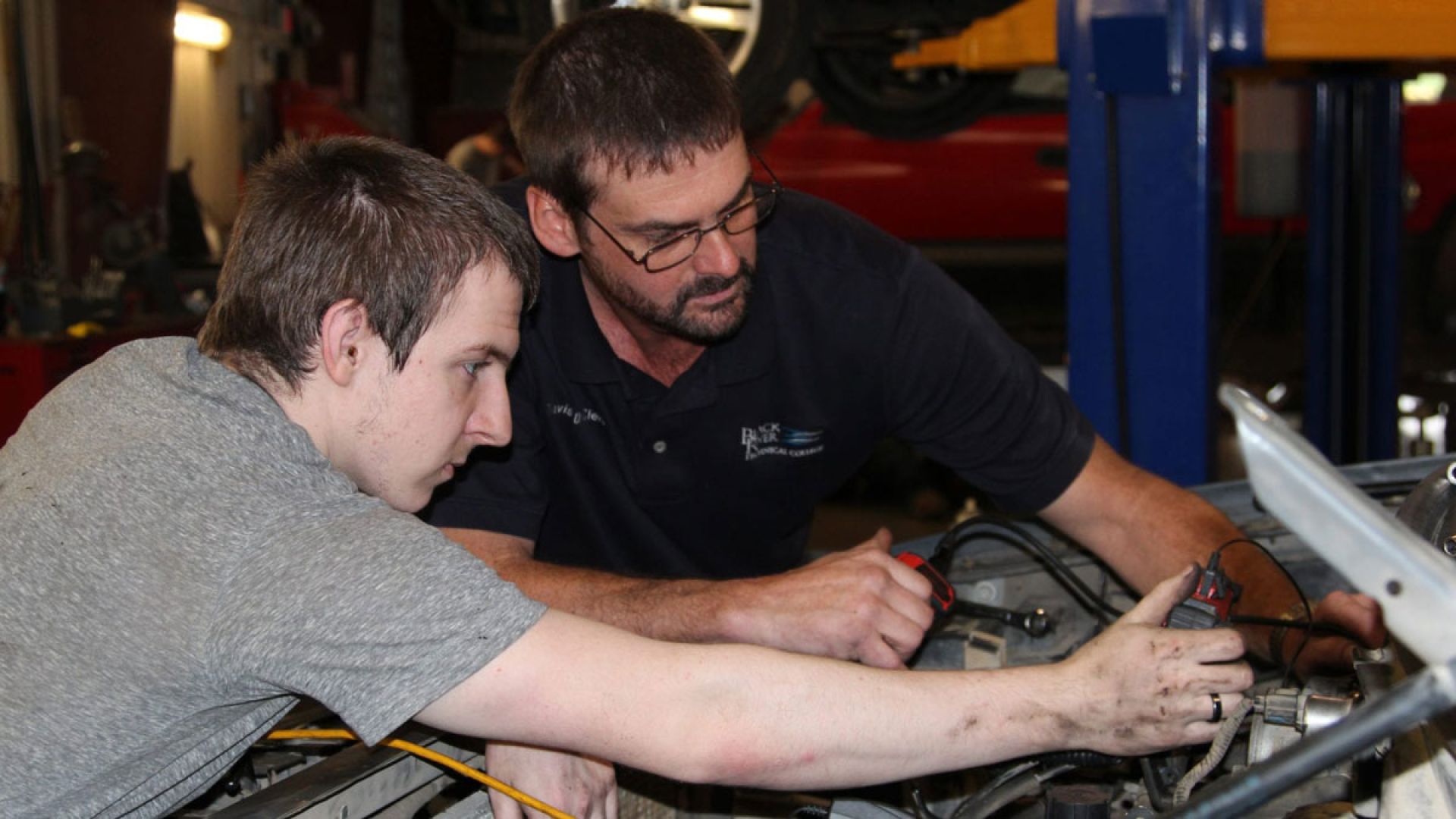 two men servicing a vehicle